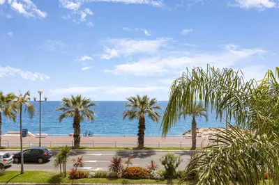 a street with palm trees and the ocean at Loft Le Galet FSHH in Nice