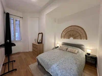 a bedroom with a bed and a dresser and a mirror at Les Orangers - 3 Pièces avec terrasse arborée in Nice