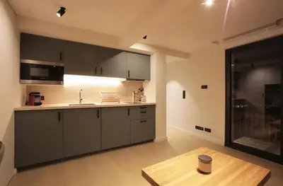 a kitchen with gray cabinets and a wooden table at Fully equiped newly refurbished studio with an incredible view in Nice in Nice