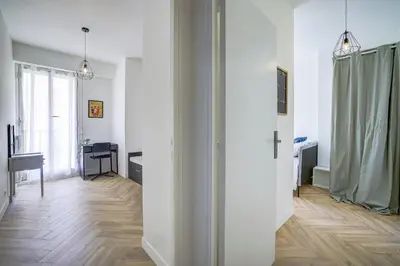a hallway with white walls and a wooden floor at Maison Bianchi - Downtown Alsace Lorraine in Nice