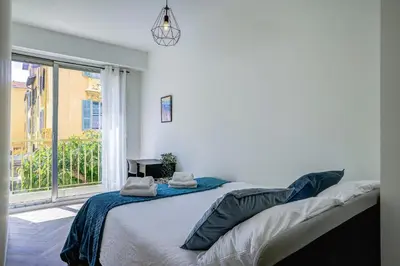 a bedroom with a bed and a large window at Maison Bianchi - Downtown Alsace Lorraine in Nice