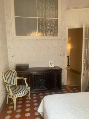 a bedroom with a bed and a chair and a window at Appartement dans le Vieux-Nice in Nice