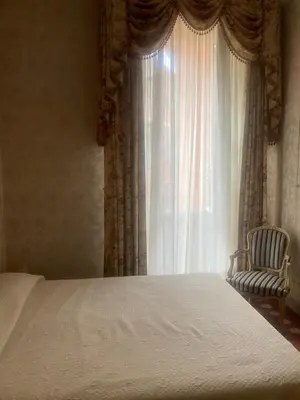 a bedroom with a bed and a chair and a window at Appartement dans le Vieux-Nice in Nice