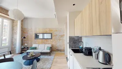 a kitchen and living room with a couch and a table at ApartHotel Riviera - BALCON BARLA - Old Port PLace du Pin in Nice
