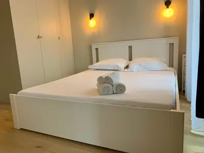 a large white bed with two towels on it at ApartHotel Riviera - BALCON BARLA - Old Port PLace du Pin in Nice