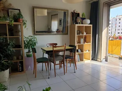 a dining room with a table and chairs and a mirror at Bel appartement lumineux T3 Terrasse in Nice
