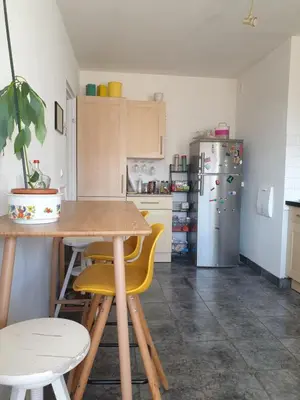 a kitchen with a table and a refrigerator at Bel appartement lumineux T3 Terrasse in Nice