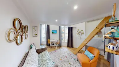 a living room with a couch and a staircase at Joli studio centre-ville Nice proche de la gare in Nice