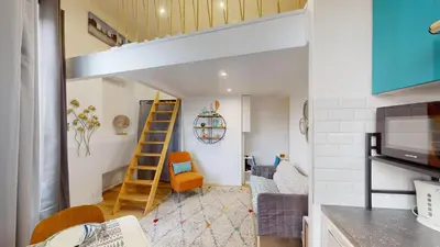a living room with a couch and a stair case at Joli studio centre-ville Nice proche de la gare in Nice