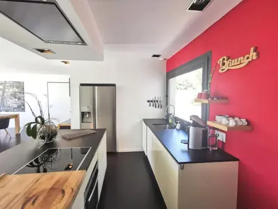 a kitchen with a red wall and a counter at Villa Les Oliviers by Interhome in Nice