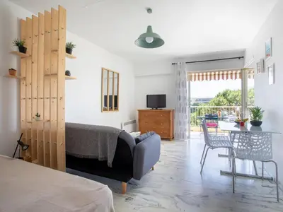 a bedroom with a bed and a desk and a table at Studio le ponant by Interhome in Saint-Laurent-du-Var