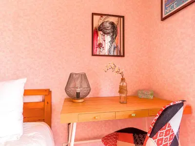 a bedroom with a wooden table with a lamp on it at Apartment Les Balcons de Battisti by Interhome in Nice