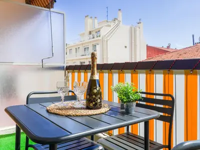 a table with a bottle of wine and glasses on a balcony at Apartment Les Balcons de Battisti by Interhome in Nice