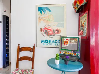 a room with a table and a tv and a picture of a car at Apartment Le Palais Foch by Interhome in Villefranche-sur-Mer