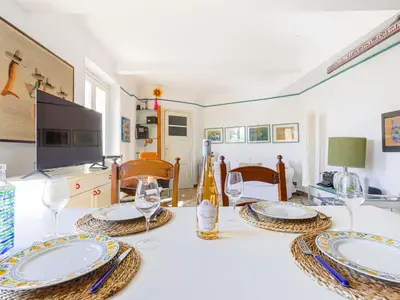a dining room with a table with plates and wine glasses at Apartment Le Palais Foch by Interhome in Villefranche-sur-Mer