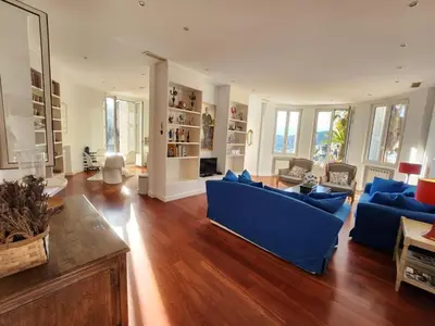 a large living room with a blue couch and wooden floors at Villa Bethanie in Villefranche-sur-Mer