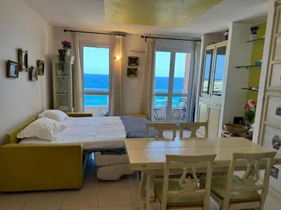 a bedroom with a bed and a table and windows at VUE mer 02 chambres 45M et parking in Nice