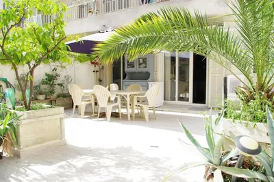a patio with a table and chairs and trees at F4 6 Couchages Terrasse Proche Centre in Nice