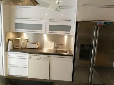 a kitchen with white cabinets and a stainless steel refrigerator at F4 6 Couchages Terrasse Proche Centre in Nice
