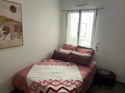 a small bed in a room with a window at Joli 3 pièces ensoleillé sur les hauteurs de Nice in Nice
