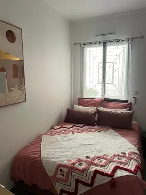 a bed in a bedroom with a window at Joli 3 pièces ensoleillé sur les hauteurs de Nice in Nice