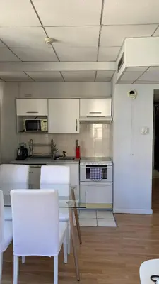 a kitchen with a glass table and white appliances at 1 bedroom flat in the best street Nice in Nice