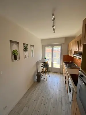 a kitchen with white walls and a wooden floor at Nice apartment - Valrose - Cosy & Chill in Nice