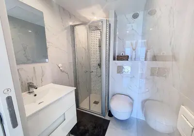 a white bathroom with a shower and a sink at Horizon bleu vue mer dernier étage clim in Saint-Laurent-du-Var