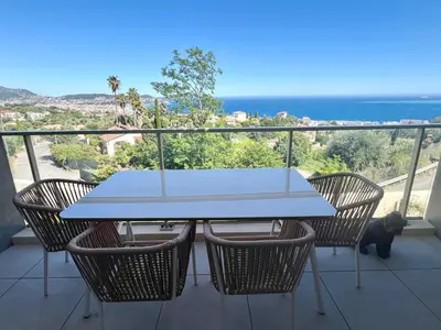 a table and chairs on a balcony with the ocean at Panoramic Sea View Appartment Blue Pearl in Nice