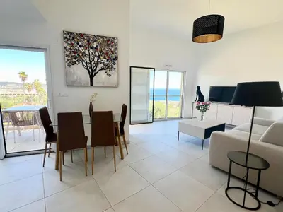 a living room with a table and chairs and a couch at Panoramic Sea View Appartment Blue Pearl in Nice