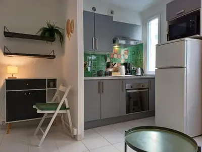 a kitchen with a white refrigerator and a chair at Appartement Nice Libération in Nice