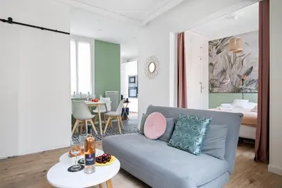 a living room with a couch and a bedroom at Pink Palace - Quartier Authentique Libération in Nice