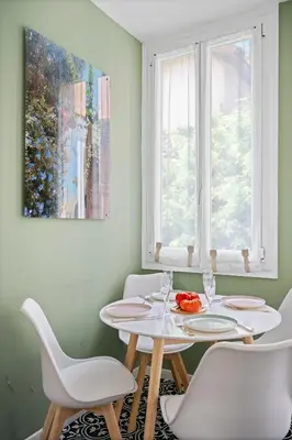 a dining room with a table and chairs and two windows at Pink Palace - Quartier Authentique Libération in Nice