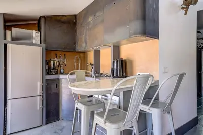 a kitchen with a table and chairs and a refrigerator at Dernier étage port de Nice in Nice