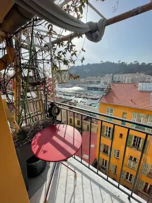 a balcony with a chair and a view of a city at Dernier étage port de Nice in Nice
