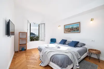 a white bedroom with a bed and a tv at FEEL HOME - VISTA Di PORTU in Nice