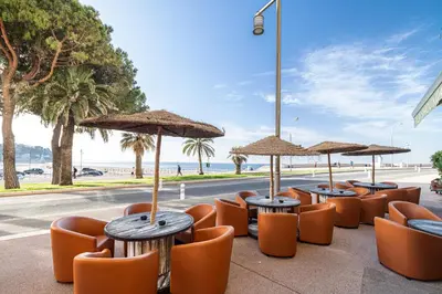 a row of tables and chairs with umbrellas on a street at FEEL HOME - VISTA Di PORTU in Nice