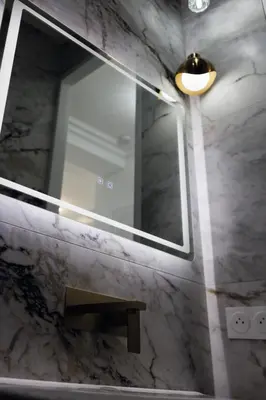 a bathroom with a mirror and a bench and a light at Appartement 3 PIECES NICE Promenade in Nice