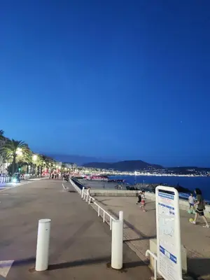 a beach with a sign and people walking on it at Appartement 3 PIECES NICE Promenade in Nice