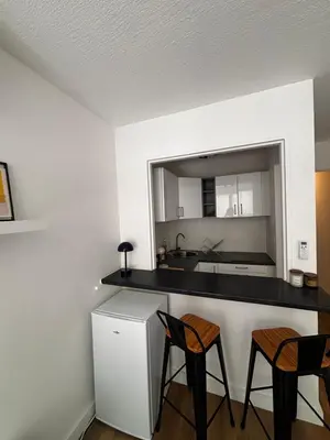 a kitchen with two chairs and a counter with a sink at Nice appartement for 2 adults with air-conditioning in Nice