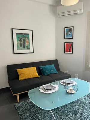 a living room with a black couch and a glass table at Perfectly located holiday place in Beaulieu-sur-Mer