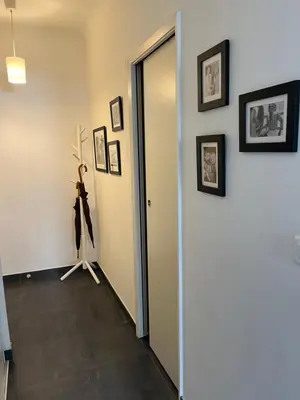a hallway with a door and pictures on the wall at Perfectly located holiday place in Beaulieu-sur-Mer
