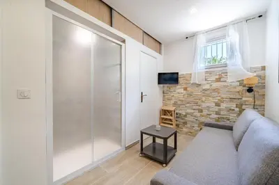 a living room with a couch and a sliding glass door at Port de Nice, Charmant studio in Nice