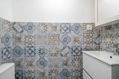 a bathroom with a sink and a tile wall at Port de Nice, Charmant studio in Nice