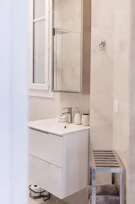 a white bathroom with a sink and a mirror at New Central Stylish 2 min from the beach Apartment in Nice