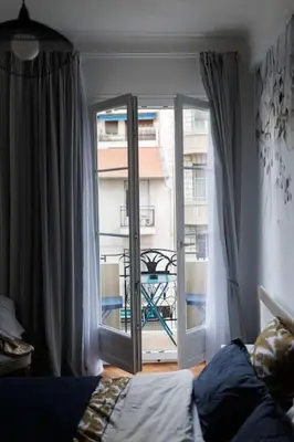 a bedroom with a window with a view of a building at New Central Stylish 2 min from the beach Apartment in Nice