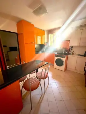 a kitchen with orange cabinets and a table and chairs at Apartment Massena - super central in Nice