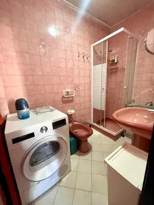a pink bathroom with a washing machine and a sink at Apartment Massena - super central in Nice