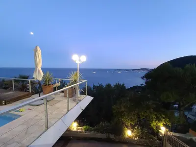 a villa with a view of the ocean at night at Eze sur mer - vue Saint Jean Cap Ferrat in Èze