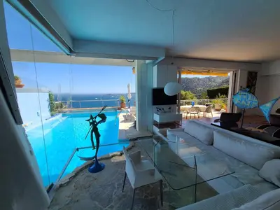 a living room with a view of a swimming pool at Eze sur mer - vue Saint Jean Cap Ferrat in Èze